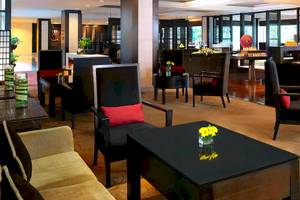 Lobby des Anantara Riverside Bangkok Resorts mit modernen Möbeln und Blumenarrangements.