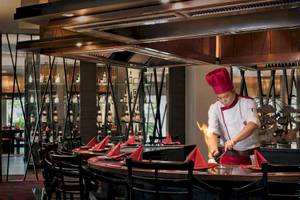 Restaurant-Interieur im Anantara Riverside Bangkok Resort mit Koch, der Essen brät