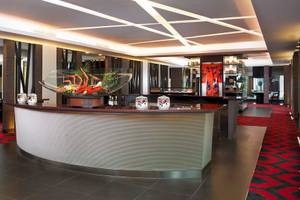 Lobby des Anantara Riverside Bangkok Resorts mit moderner Einrichtung und rotem Teppich.