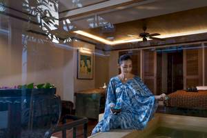 Frau im blauen Kleid am Rande eines Whirlpools im Spa-Bereich des Anantara Riverside Bangkok Resort