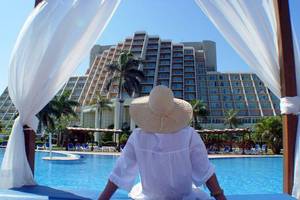 Frau im Hut vor dem Blau Varadero Hotel am Pool