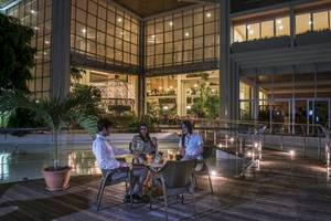 Drei Personen sitzen auf der Terrasse des Blau Varadero Hotels und genießen ein Abendessen.