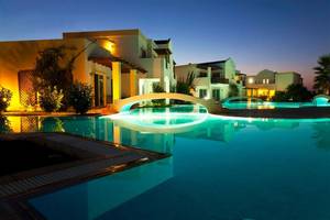 Nachtansicht des beleuchteten Swimmingpools im Atlantica Marmari Beach Hotel.