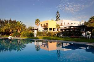 Außenbereich des Atlantica Marmari Beach Hotels mit Swimmingpool und Gebäuden.