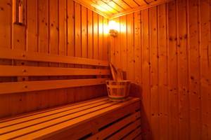 Sauna im Atlantica Marmari Beach Hotel mit hölzernen Wänden und Bänken.