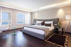 Schlafzimmer im Atlas Amadil Beach Hotel mit Meerblick, Bett, Nachttischen und Dekor.