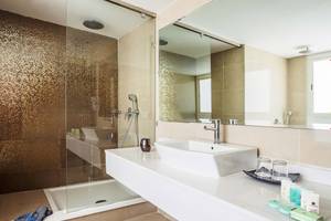 Badezimmer im Atlas Amadil Beach Hotel mit einer großen Glasdusche und einem Waschbecken.
