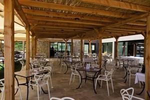 Außenbereich des Baglioni Resort Sardinia mit überdachter Terrasse und Tischen