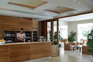 Barbereich im Atlantica Holiday Village Kos mit Barkeeper und gefüllten Flaschen