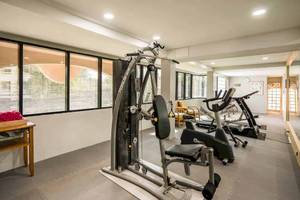 Fitnessraum im Chaba Samui Resort mit mehreren Trainingsgeräten und großen Fenstern.