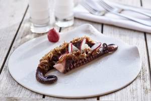 Ein Teller mit gebratenem Tintenfisch, Zwiebeln und Rettich auf einem Holztisch.