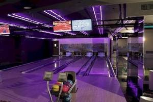 Bowlinghalle im Kempinski Hotel Muscat mit violetten Lichtern und Bowlingbahnen