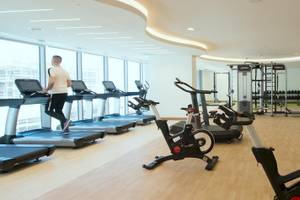 Fitnesscenter im Kempinski Hotel Muscat mit einem Mann, der auf einem Laufband läuft.
