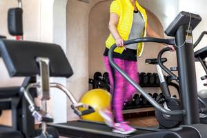 Frau im Colonna Hotel Du Golf Fitnessbereich auf dem Laufband.