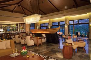 Lobby des Dreams Las Mareas Costa Rica Hotels mit Bar, großen Fenstern und moderner Einrichtung.
