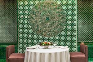 Foto von einem Tisch im Allegro Agadir Hotel mit grünen Wänden und einem Blumenarrangement.