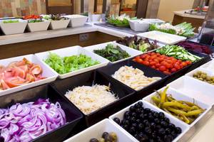 Buffet im Hotel Tagoro Family & Fun Costa Adeje mit verschiedenen Salaten, Tomaten, Gurken, Oliven und anderen Zutaten.