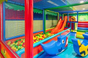 Kinderspielplatz im Tagoro Family & Fun Costa Adeje mit bunten Spielgeräten und einer Rutsche.