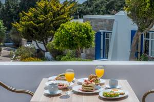 Frühstück auf dem Balkon im Naxos Palace Hotel mit Orangensaft, Gebäck und mehr.