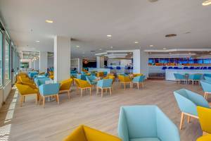 Innenbereich des SBH Maxorata Resorts mit blauen und gelben Stühlen und Tischen.