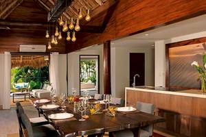 Innenansicht des Esszimmers im Secrets Papagayo Costa Rica Hotel mit langem Esstisch, Stühlen und moderner Einrichtung.