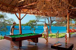 Mann und Frau spielen Pool auf Holzdeck mit Meerblick im Secrets Papagayo Costa Rica