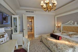 Schlafzimmer im Nirvana Dolce Vita Hotel mit großem Bett, Nachttischen und Fernseher.