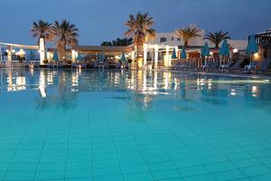 Nachtansicht des Schwimmbeckens und der Lounge-Bereiche des Europa Beach Hotel & Spa.