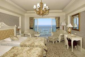 Doppelzimmer mit Meerblick im Hotel Nirvana Dolce Vita mit zwei Betten, einem Schreibtisch und einem Balkon.