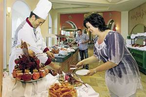 Im Mahdia Beach & Aqua Park Hotel serviert ein Koch ein Buffet mit verschiedenen Gerichten.