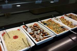 Mehrere Speisen in weißen Schalen auf einem Buffet im Europa Beach Hotel & Spa.