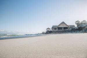 Strand des Iberostar Origin Bella Costa Hotels mit Sonnenliegen und Gebäuden