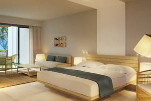 Innenansicht eines Schlafzimmers im Preskil Island Resort mit großem Bett, Couch, Tisch und Lampen.