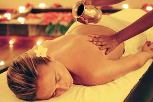 Frau genießt Massage im Preskil Island Resort mit Kerzen und Blumen im Hintergrund