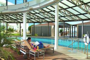 Frau liest Buch am Pool im Louis Ledra Beach Hotel