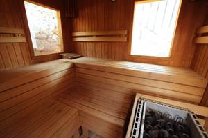 Innenansicht einer Holzsauna im Marble Arch Hotel By Perili Datca mit zwei Fenstern und Holzbänken