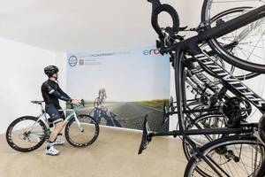 Im Alua Leo Hotel steht ein Fahrrad neben einer Wand mit einem großen Bild von Radfahrern.