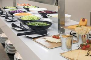 Buffet-Tisch im Alua Leo Hotel mit verschiedenen Salaten, Käse und Crackern.
