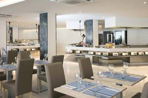 Innenansicht des Alua Leo Hotels mit Restaurant und Tischen, Stühlen und Geschirr.