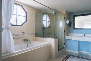 Badezimmer im Iberostar Laguna Azul Hotel mit Badewanne, Dusche und Spiegel.