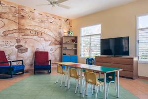 Kinderzimmer im Iberostar Laguna Azul Hotel mit einem großen Wandbild von Kuba und einem Fernseher.