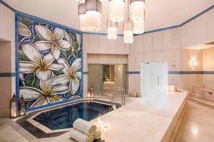 Innenbereich des Spas im Sugar Beach Mauritius mit einem Whirlpool, Marmorboden und dekorativen Wandfliesen.