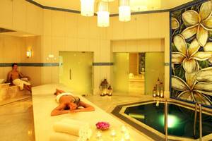 Spa-Bereich im Sugar Beach Mauritius Hotel mit einer Frau, die sich entspannt und einem Mann, der sitzt.