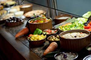 Buffet mit vielen Speisen im Amphoras Beach, einschließlich Salate, Gemüse und Früchte.