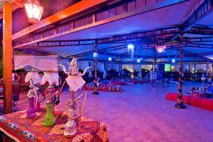 Loungebereich im Amphoras Beach Hotel mit bunten Lichtern, Wasserpfeifen und Liegen.
