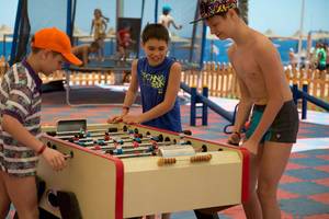 Drei Jungen spielen Tischfußball im Amphoras Beach Hotel.