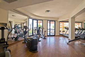 Fitnessstudio im Amphoras Beach Hotel mit verschiedenen Trainingsgeräten und großen Fenstern
