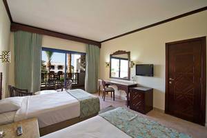 Doppelzimmer im Amphoras Beach Hotel mit zwei Betten, Balkon und Fernseher.