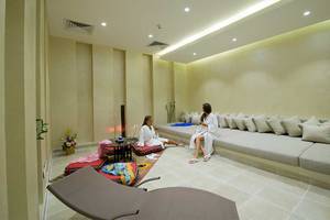 Zwei Frauen im weißen Bademantel sitzen auf Kissen im Amphoras Beach Hotel Lounge