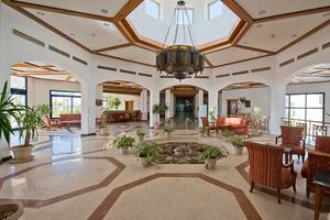 Lobby des Amphoras Beach Hotels mit Innenhof, Brunnen, Möbeln und Pflanzen.